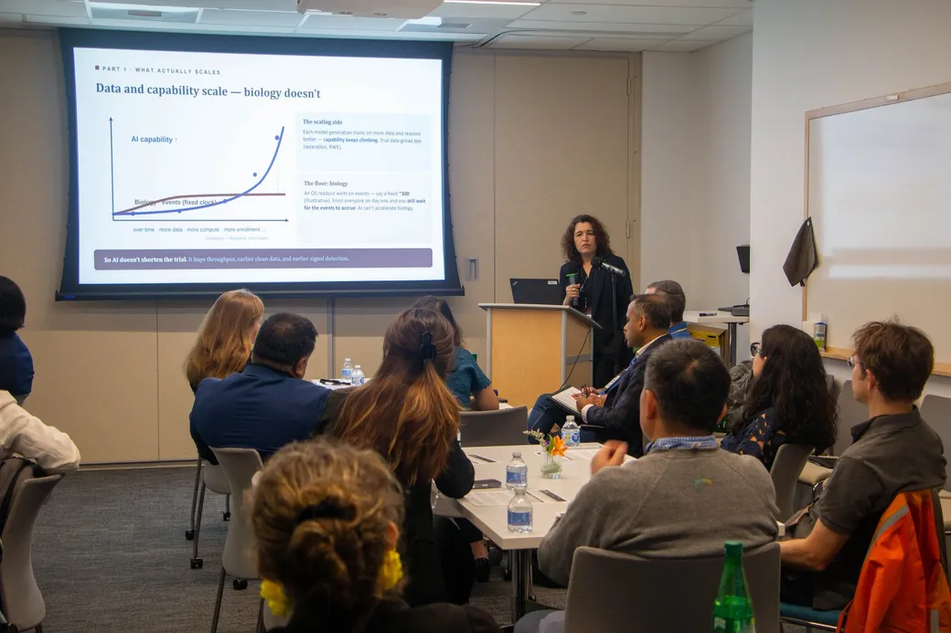 Dr. Savina Jaeger speaking beside a slide reading Data and capability scale, biology doesn't.