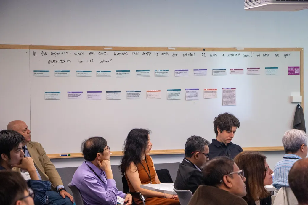 The wall of answer cards beneath the handwritten question, with guests seated in front of it.