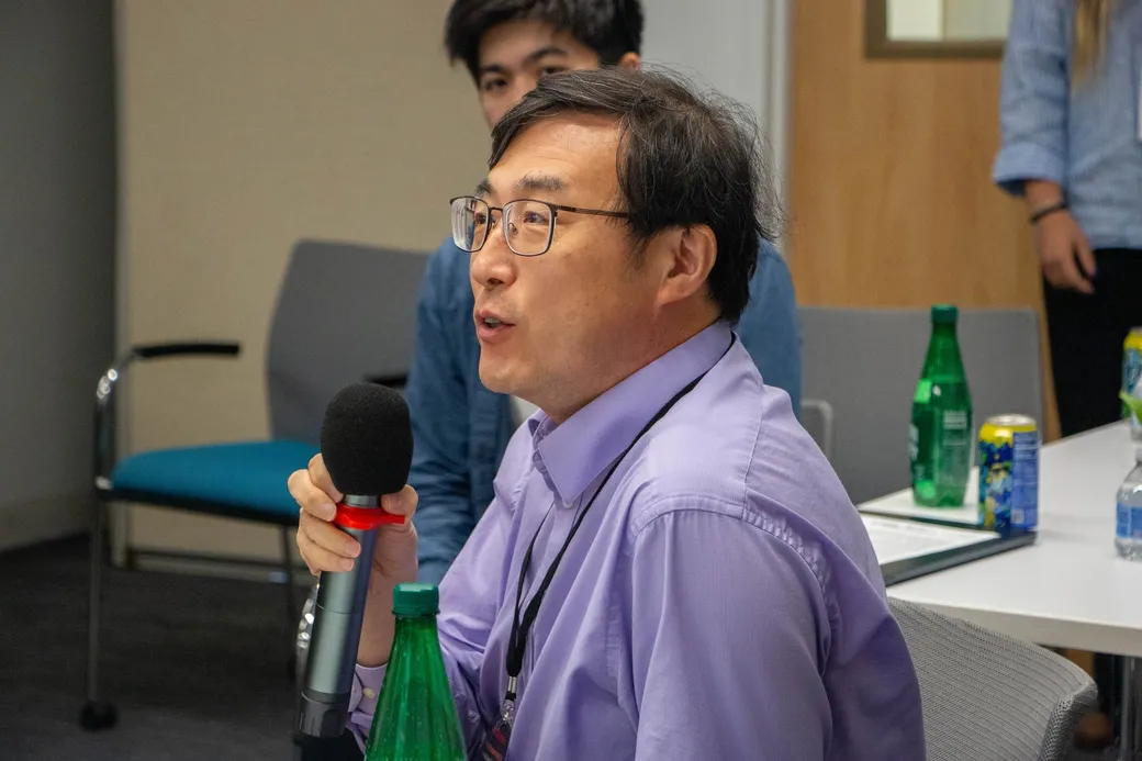A guest asking a question with a microphone during the audience block.