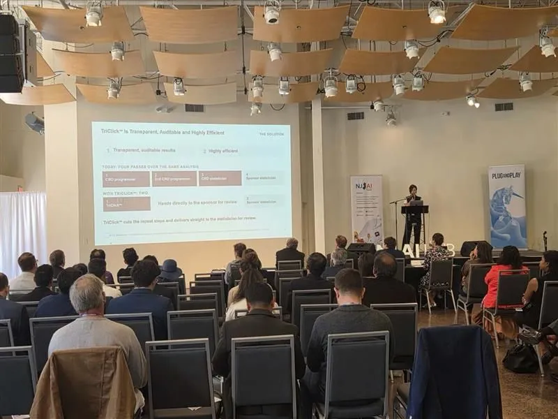 Hill Research presenting a TriClick slide to a seated audience at the NJ AI Hub Accelerator Selection Day at Grounds for Sculpture